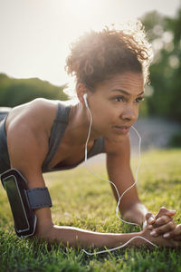 Close-up of woman in plank position on grassy field