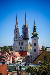 View of buildings in town against blue sky