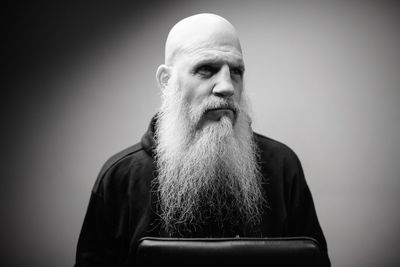 Portrait of man looking away against gray background