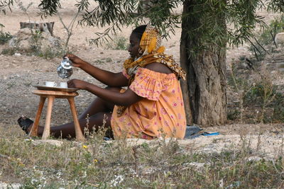 Rear view of woman sitting on field