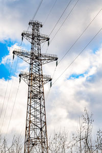 View of a metal pole of high voltage power lines against the background of a cloudy rainy sky