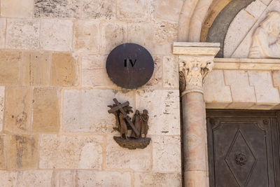 Low angle view of cross on wall