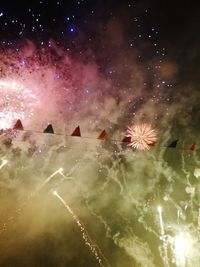 Low angle view of firework display in sky at night