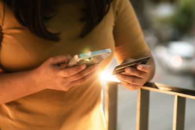 Midsection of woman using mobile phone