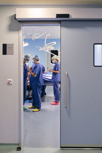 Doctors wearing face mask having discussion while standing in operation room at hospital