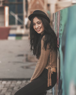 Young woman looking away while standing outdoors