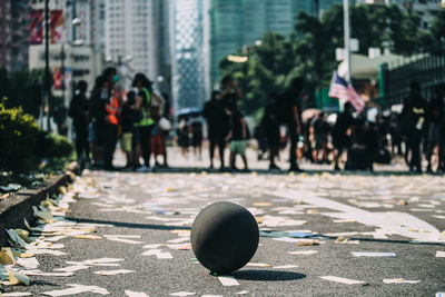 People walking on road by buildings in city