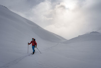 People skiing on snowcapped mountain against sky