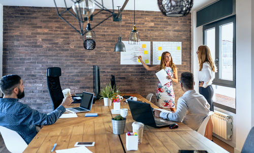 Businesswoman explaining to colleagues in meeting at office