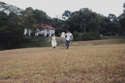 People playing on field against trees