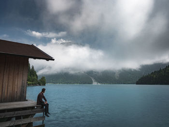 Man standing on lake against sky