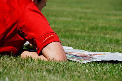 Close-up of man reading newspaper on field