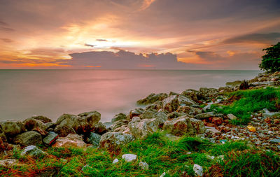 Rocks on stone beach at sunset. beautiful landscape of calm sea. tropical sea at dusk. 