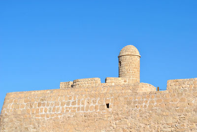 Low angle view of castle against clear blue sky