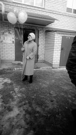 Full length of woman standing in front of building