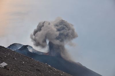 Smoke emitting from volcanic mountain against sky