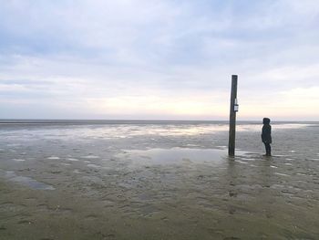 Man standing on beach against sky