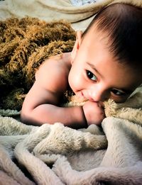 Close-up of cute baby girl lying on carpet