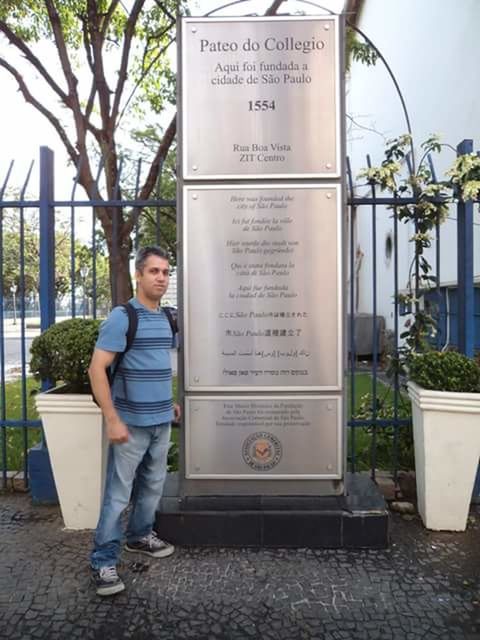 YOUNG MAN STANDING IN FRONT OF AN ANIMAL