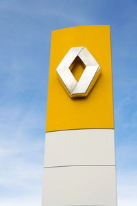 Low angle view of yellow flag against blue sky