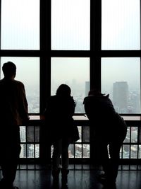 Rear view of silhouette people standing in city