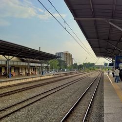 Railway tracks at railroad station against sky
