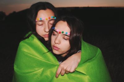 Lesbian couple wearing felt make-up wrapped in green fabric