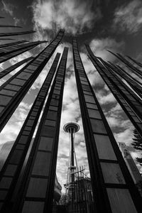Low angle view of art installation and space needle against cloudy sky