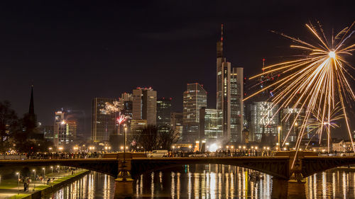 Illuminated bridge over river at night