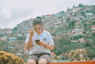 Full length of teenage girl using mobile phone