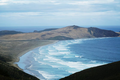 Scenic view of sea and mountains against sky