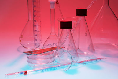 Close-up of laboratory glassware on colored background