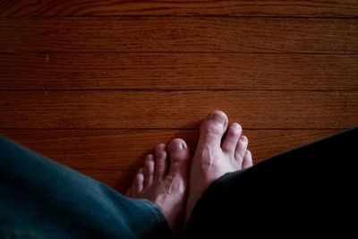 Low section of woman relaxing on tiled floor