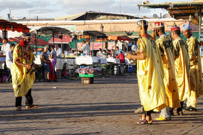 Rear view of people walking on street in city