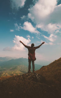 Full length of man standing on mountain against sky