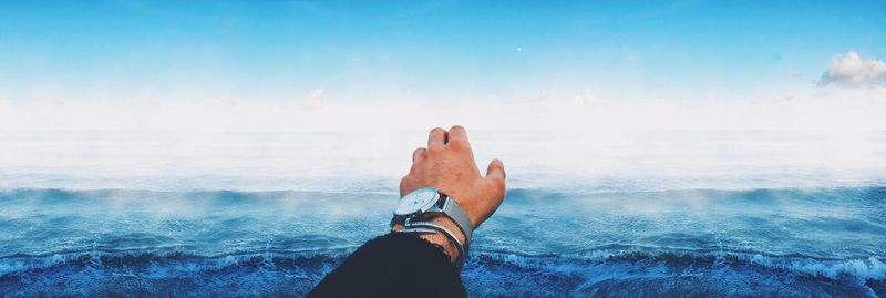 Hand of a man against wavy sea