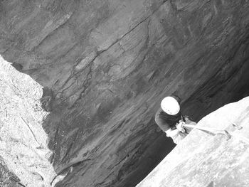 High angle view of man climbing rock