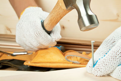 Close-up of craftsperson hammering nail at workshop