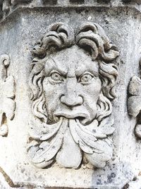 Close-up of old statue against wall