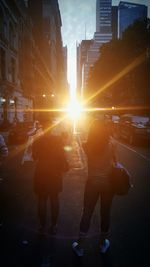 Woman standing on city street during sunset