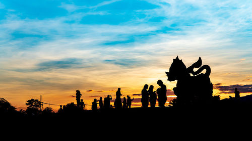 Silhouette people against sky during sunset