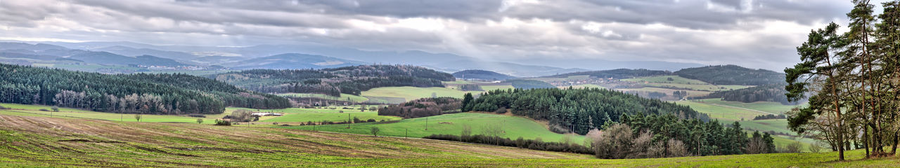 Panoramic view of agricultural field against sky