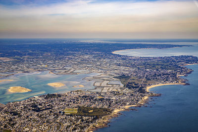 Aerial view of sea and buildings against sky