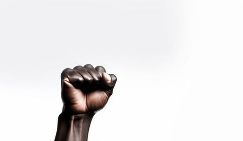 Cropped hand of woman holding nail against white background