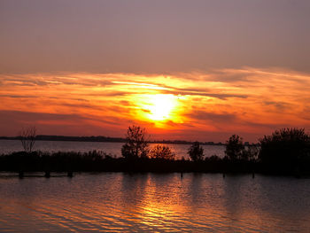 Scenic view of lake against romantic sky at sunset