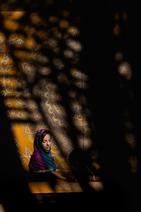 Silhouette woman looking through window