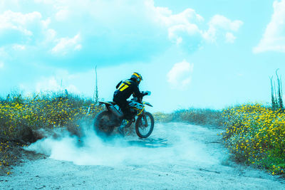 Man riding motorcycle against sky