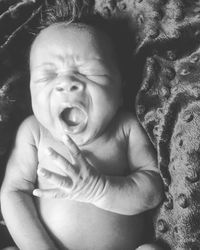 Close-up of baby girl lying on bed