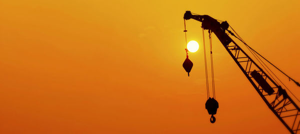 Low angle view of street light against orange sky