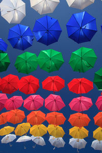 Low angle view of multi colored umbrellas hanging on paper
